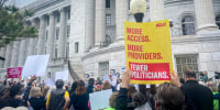 Abortion rights supporters rally with banners.